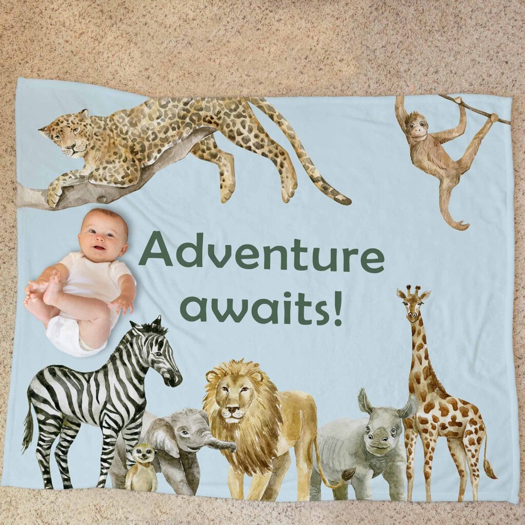 a baby laying on a blanket with safari animals